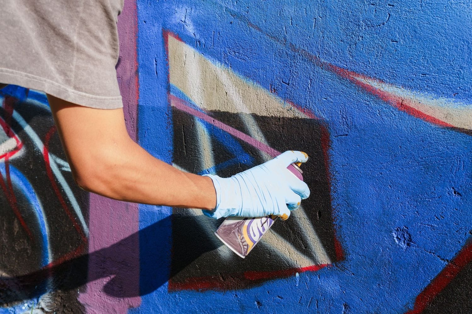 Spraydosen im Einsatz bei professionellen Graffiti Auftragsarbeiten – Detailaufnahme mit kräftigen Farben