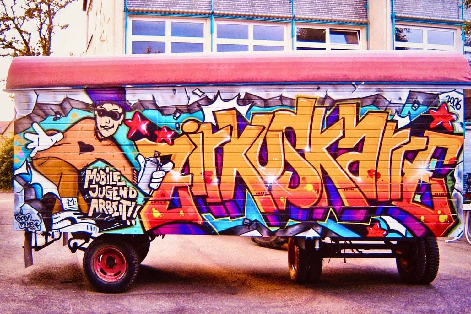Detailaufnahme der ersten Seite der Zirkuskarre – buntes Graffiti-Projekt mit Jugendlichen im Rahmen der mobilen Jugendarbeit in Stuttgart-Leinfelden.