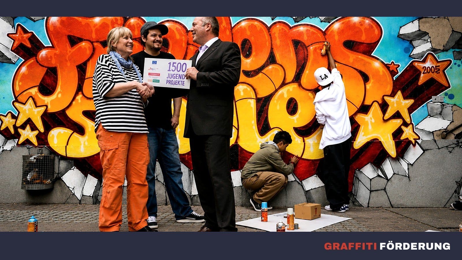 Preisgekröntes Friedensschule-Mural in Stuttgart – Scheck-Übergabe mit Open Mike vor dem bunten Wildstyle-Graffiti