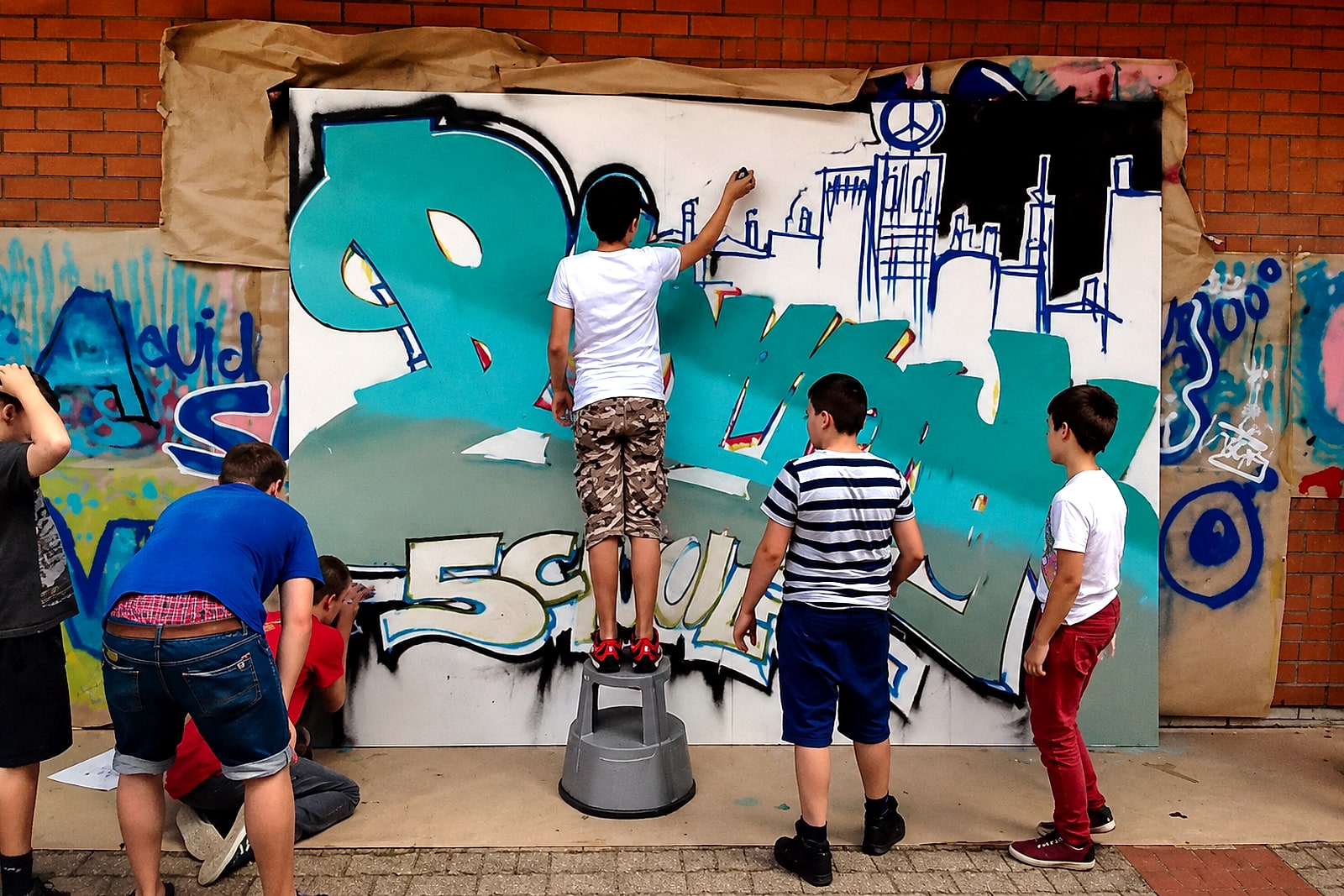 Schüler:innen der Bismarckschule Stuttgart-Feuerbach sprühen gemeinsam am Graffiti-Piece – Workshop mit Open Mike.