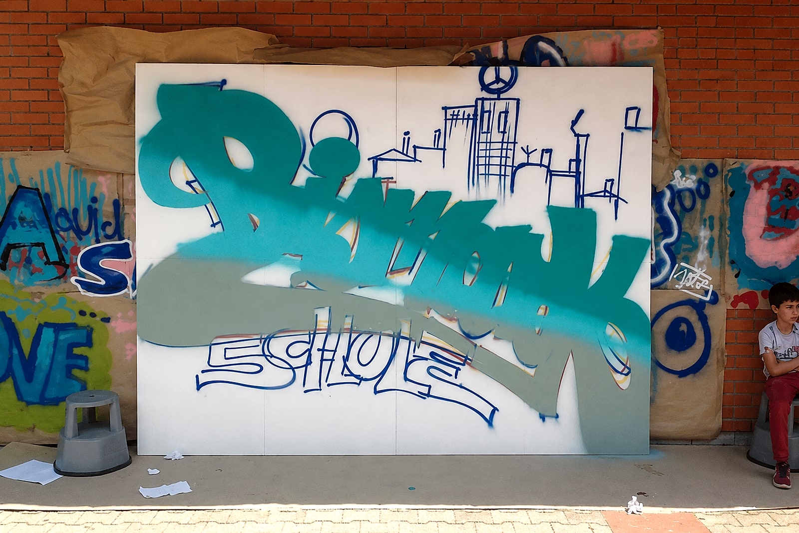 Das »Bismarck Schule«-Graffiti im Entstehen: Outline und Fläche auf großen Holzplatten beim Workshop in Stuttgart-Feuerbach.