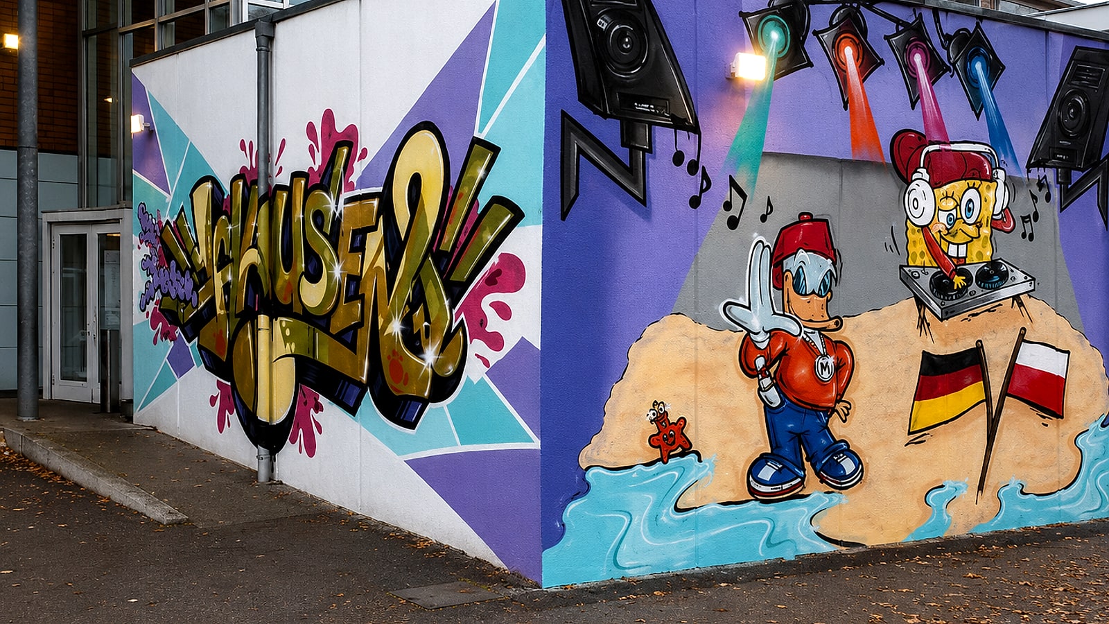 Große Graffiti-Fassade am Kinder- und Jugendhaus Hausen in Stuttgart: goldener »HAUSEN«-Schriftzug und eine Comic-Party-Szene mit DJ-Figuren, Deutschland- und Polen-Flagge.