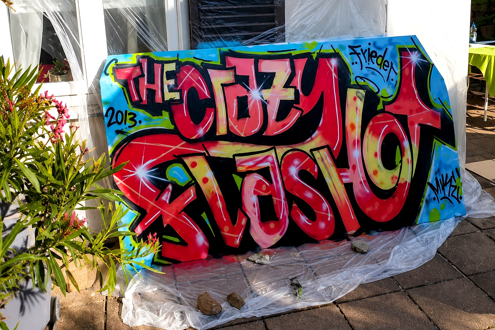 Das »The Crazy Flash«-Graffiti-Board im Garten, umgeben von Grün – Ergebnis des Graffiti-Kindergeburtstags in Stuttgart