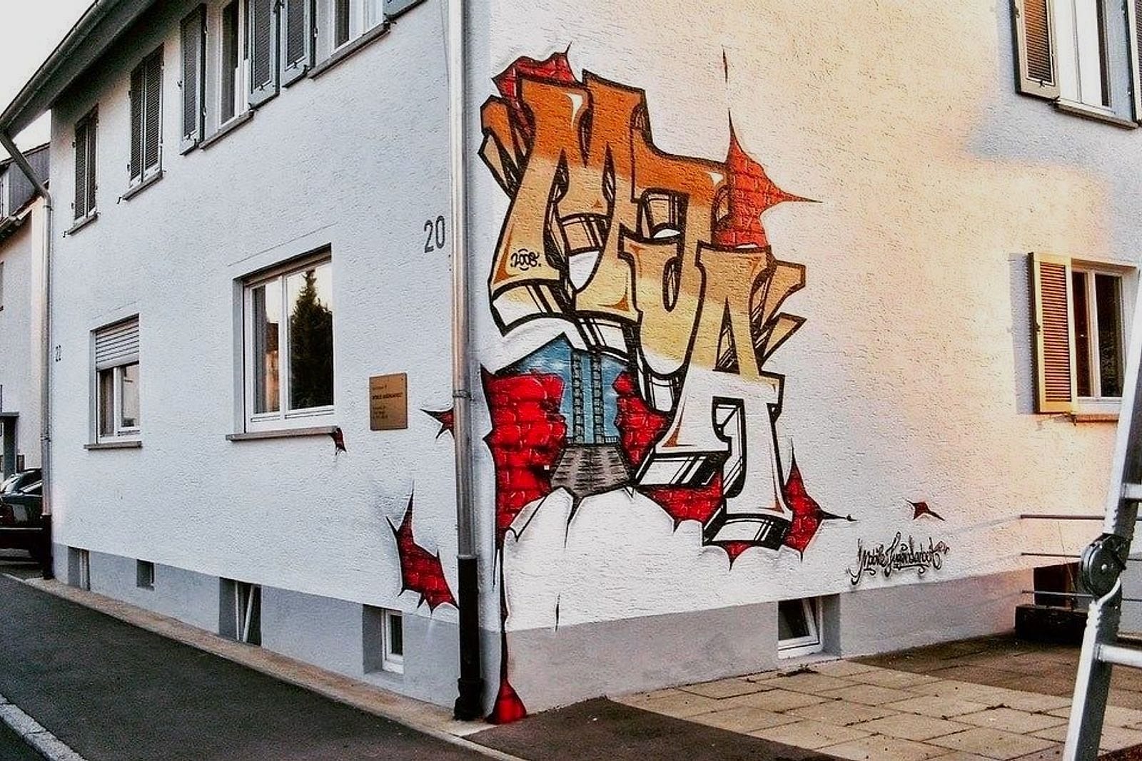 Simple-Style-Graffiti-Piece MJS mit dem Fellbacher Wahrzeichen an einer Hausfassade von Open Mike