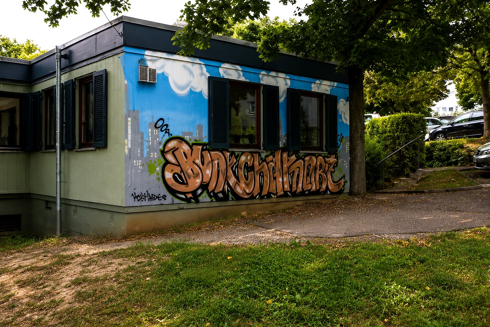 Graffiti-Mural mit Skyline und Wolken an einer Wand des Treffpunkts Rötenberg in Aalen.