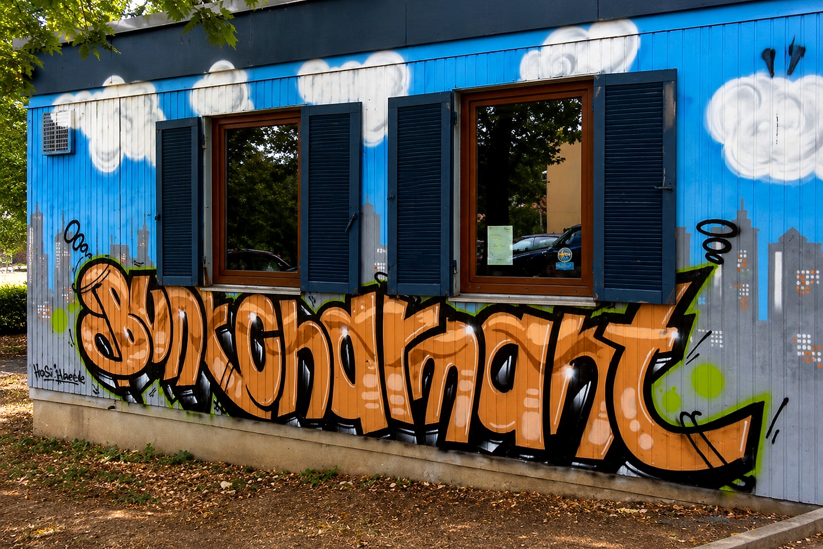Graffiti-Schriftzug in Orange mit Skyline an der Fassade des Treffpunkts Rötenberg in Aalen.