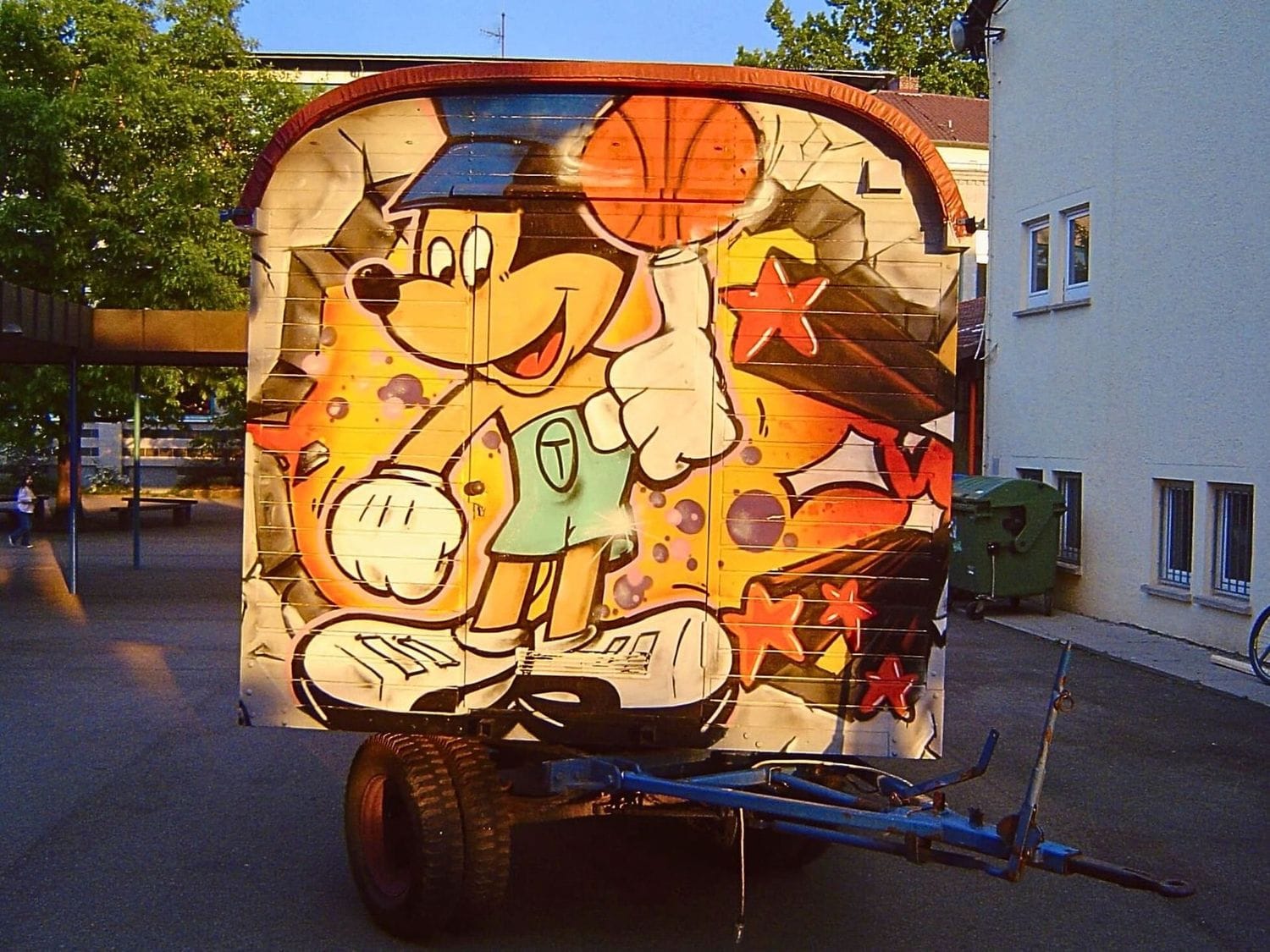 Jugendliche sprayen gemeinsam im Graffiti-Workshop in Stuttgart-Leinfelden – kreative Gestaltung der Zirkuskarre mit professioneller Anleitung durch Graffiti Coach Open Mike.