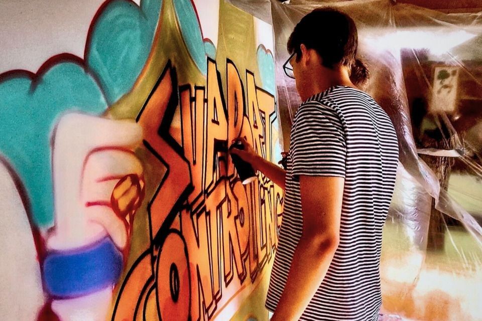 Team von Porsche gestaltet beim Urban-Art-Teamevent in Weissach gemeinsam eine große Graffiti-Holzplatte